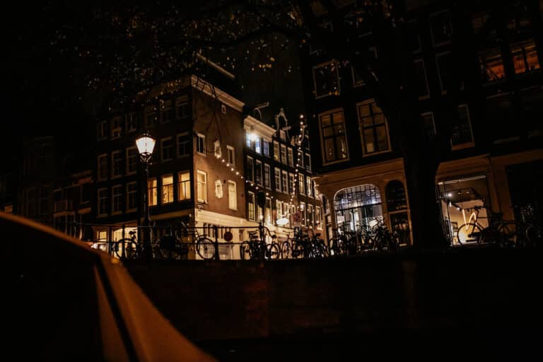 Amsterdam night canal cruise with historic buildings in the background