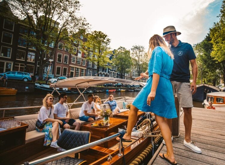 Passengers boarding a flagship boat for a shared Amsterdam cruise